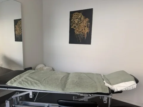 Behandlingsbenk med grønt håndkle, klar for manuell behandling og kraniosakralterapi